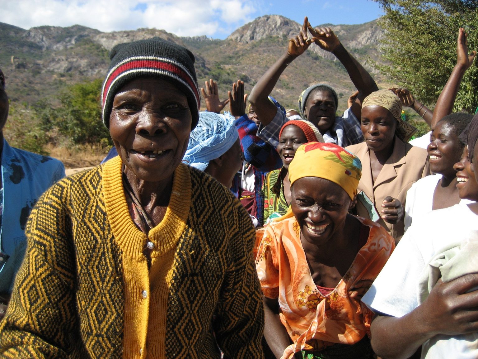 Community members smiling with mountains in background